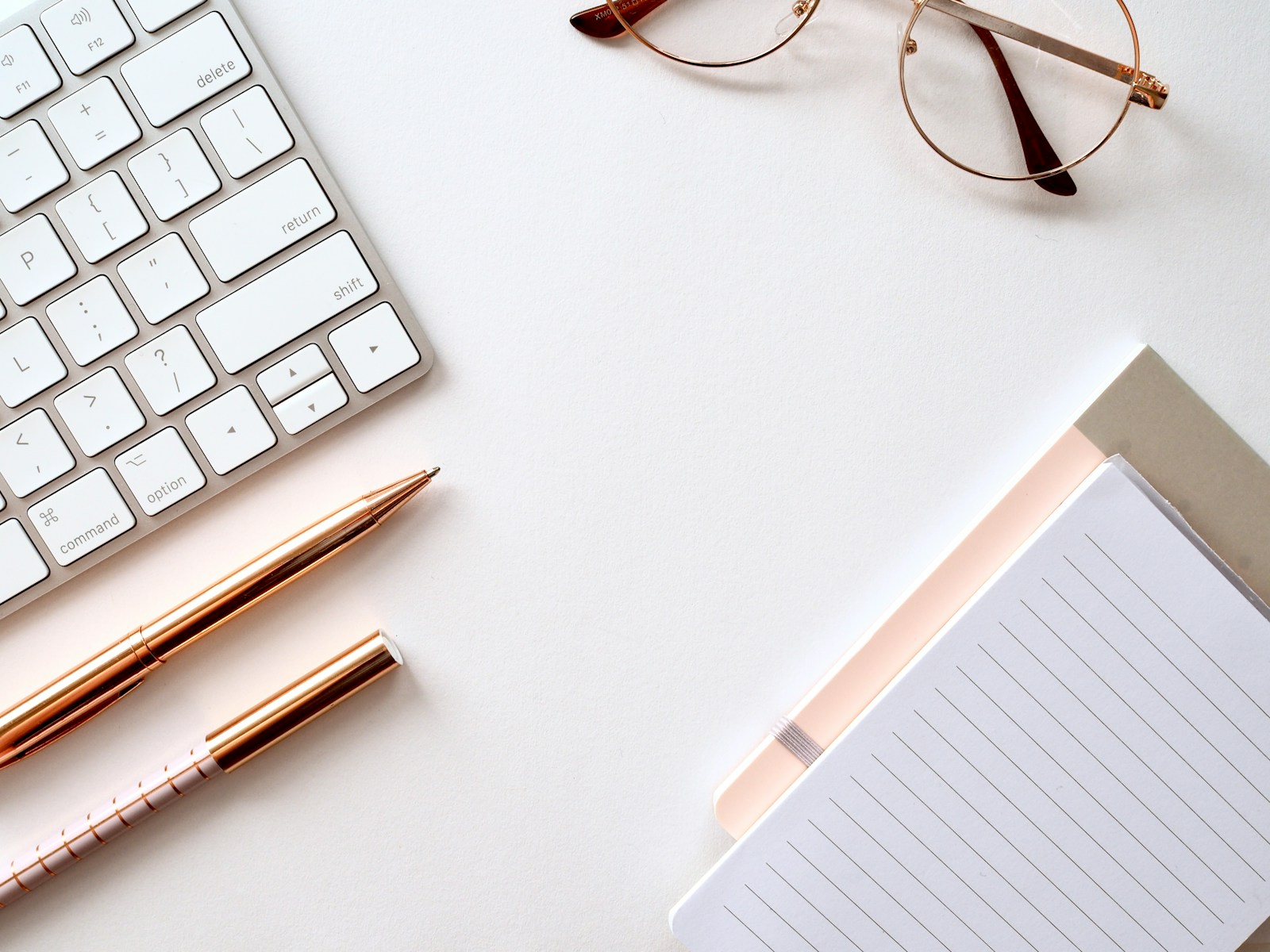 a keyboard and pen on a white surface